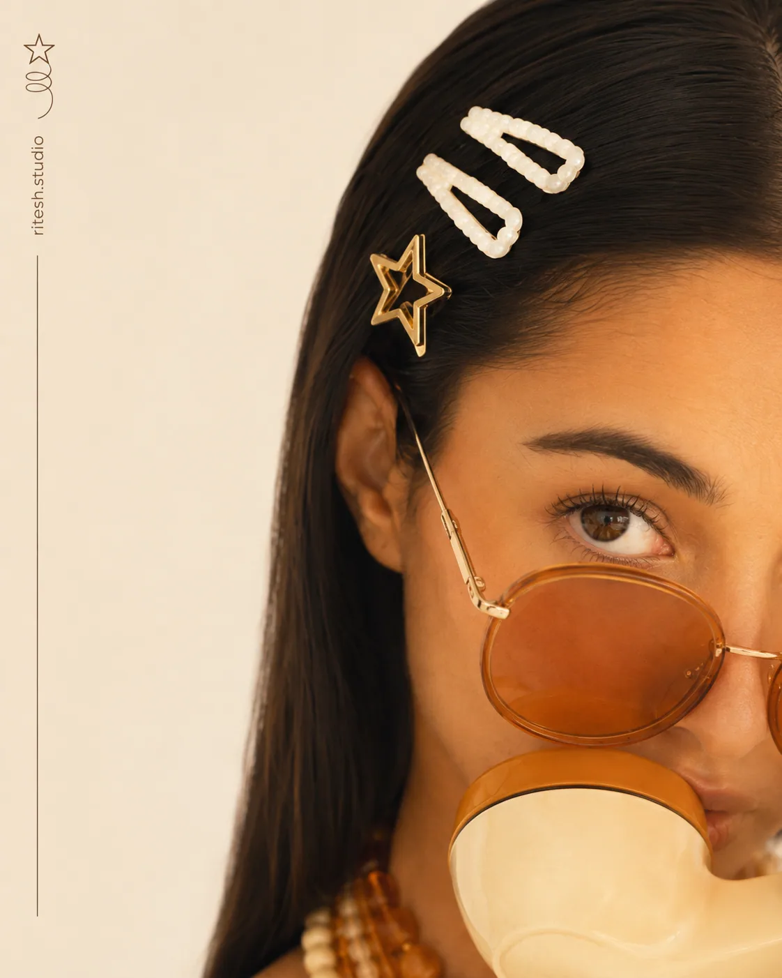Close detail of orange sunglasses and gold hair clips