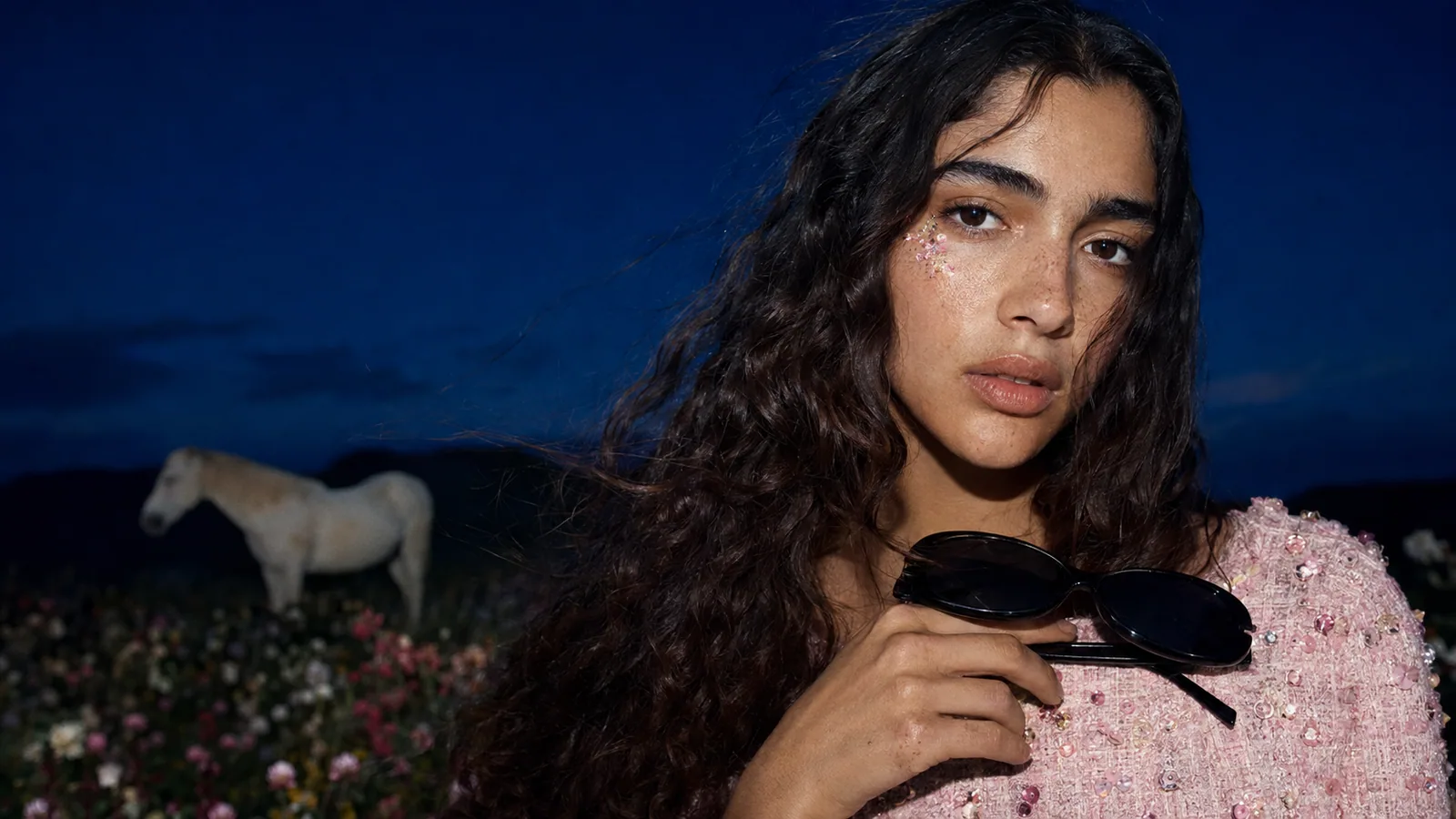 Close portrait in a pink dress with a white horse and flowers at dusk